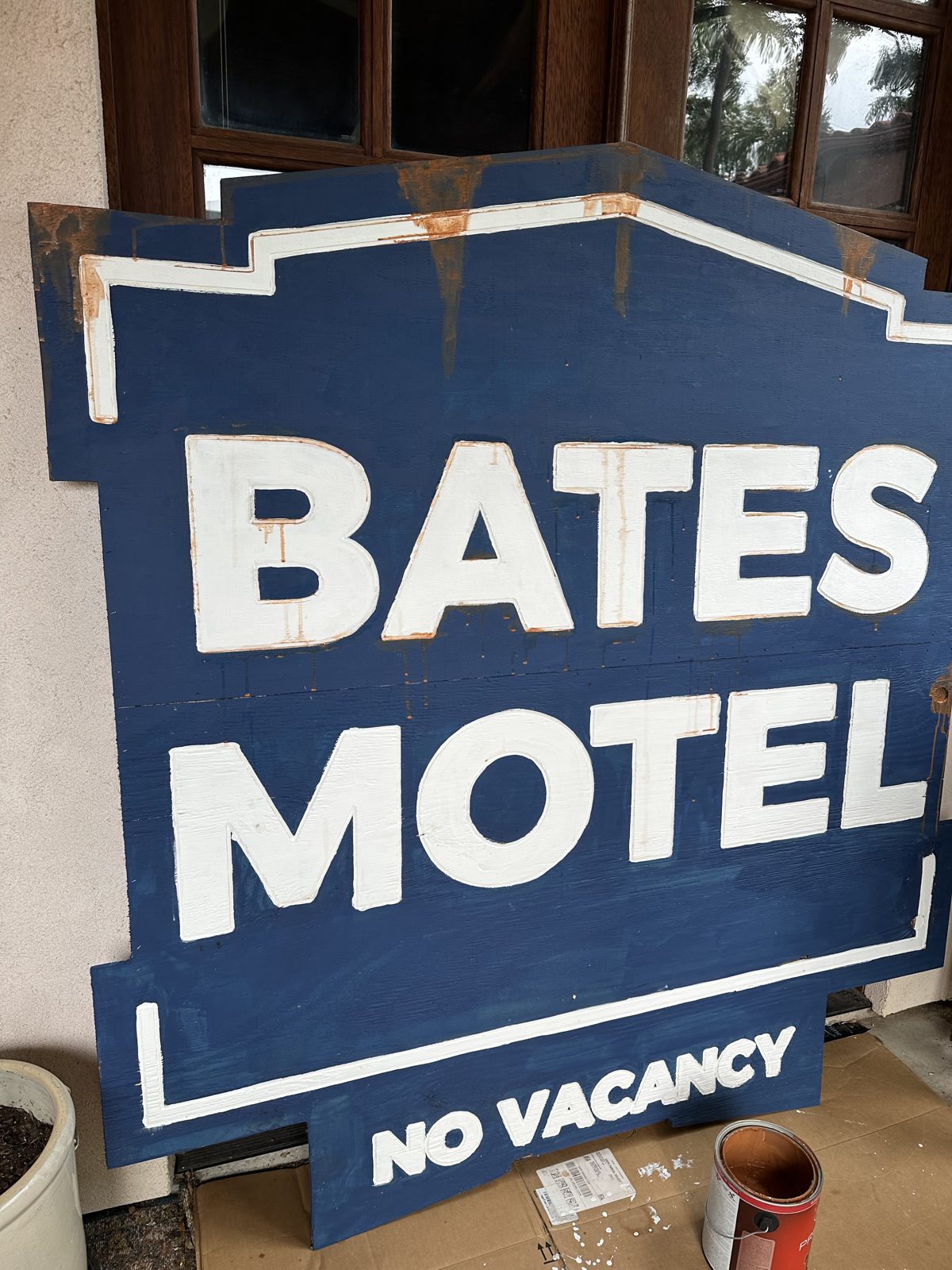 Watered-down rust paint dripping down a blue Halloween motel sign
